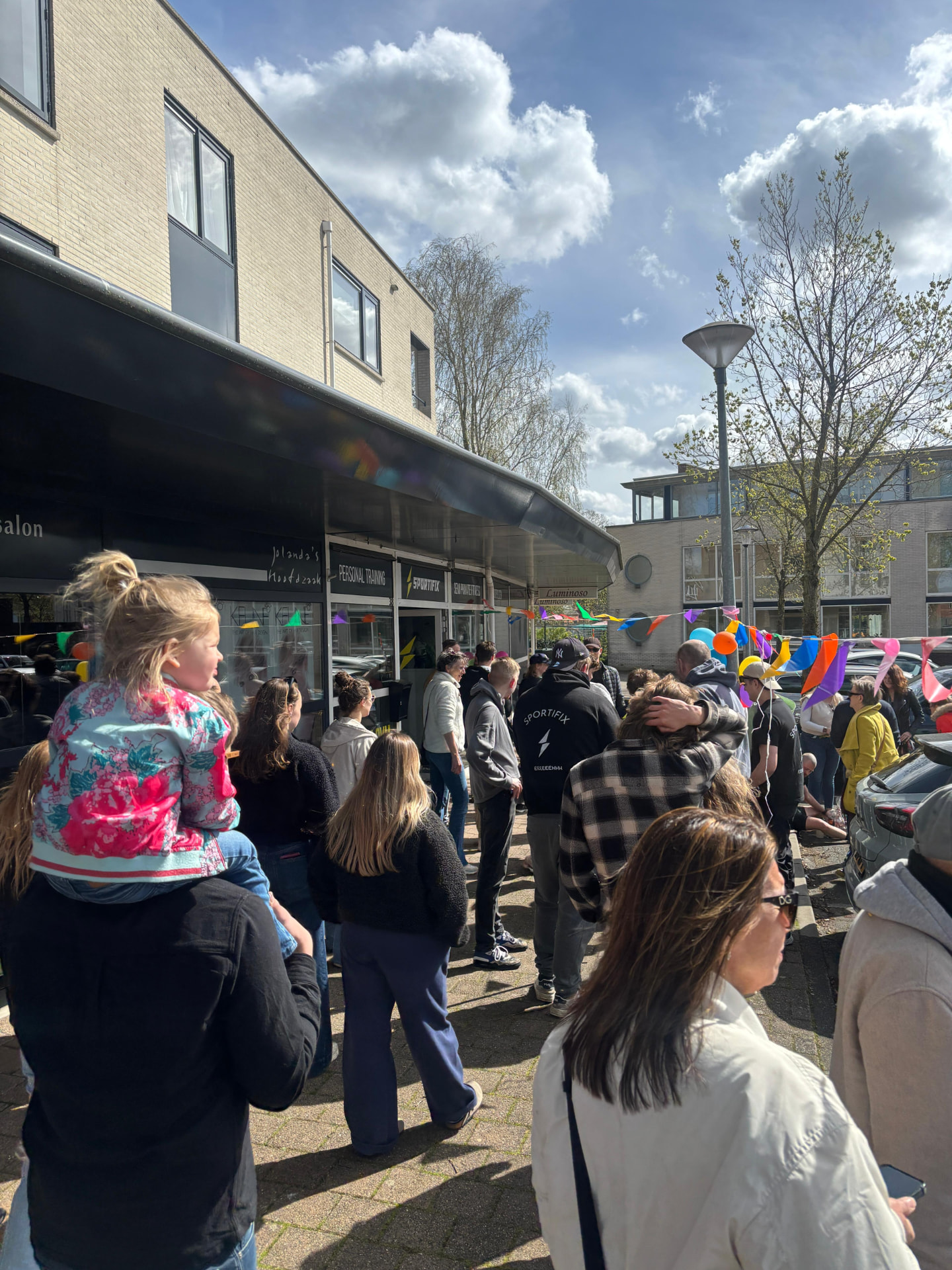 Toeschouwers met vlaggetjes bij de finish
